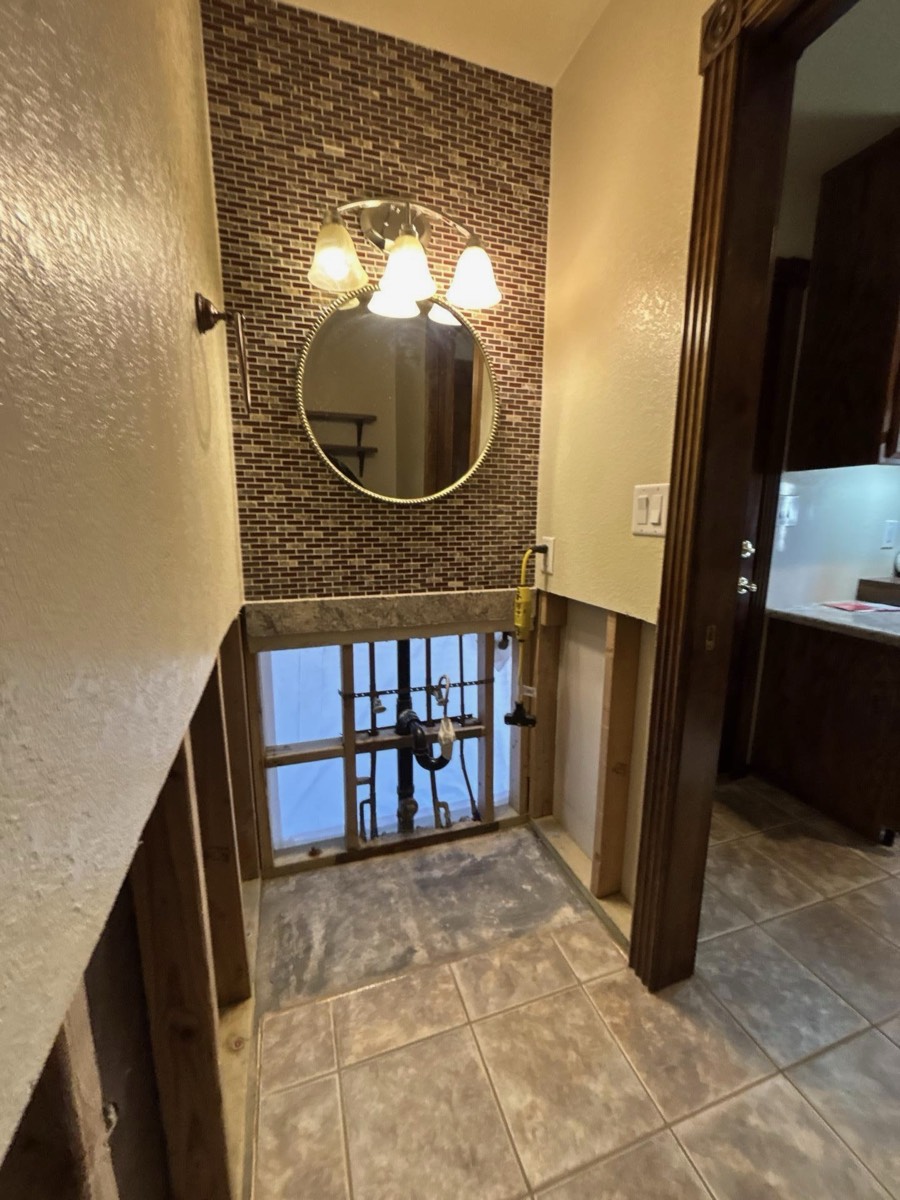 Bathroom water damage: flood cuts and vanity demo exposing plumbing, Bakersfield CA
